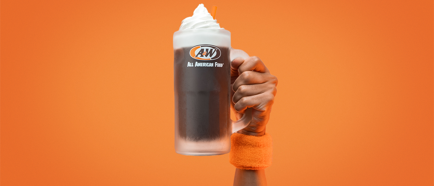 A person holding an A&W Root Beer Float in a frosty mug